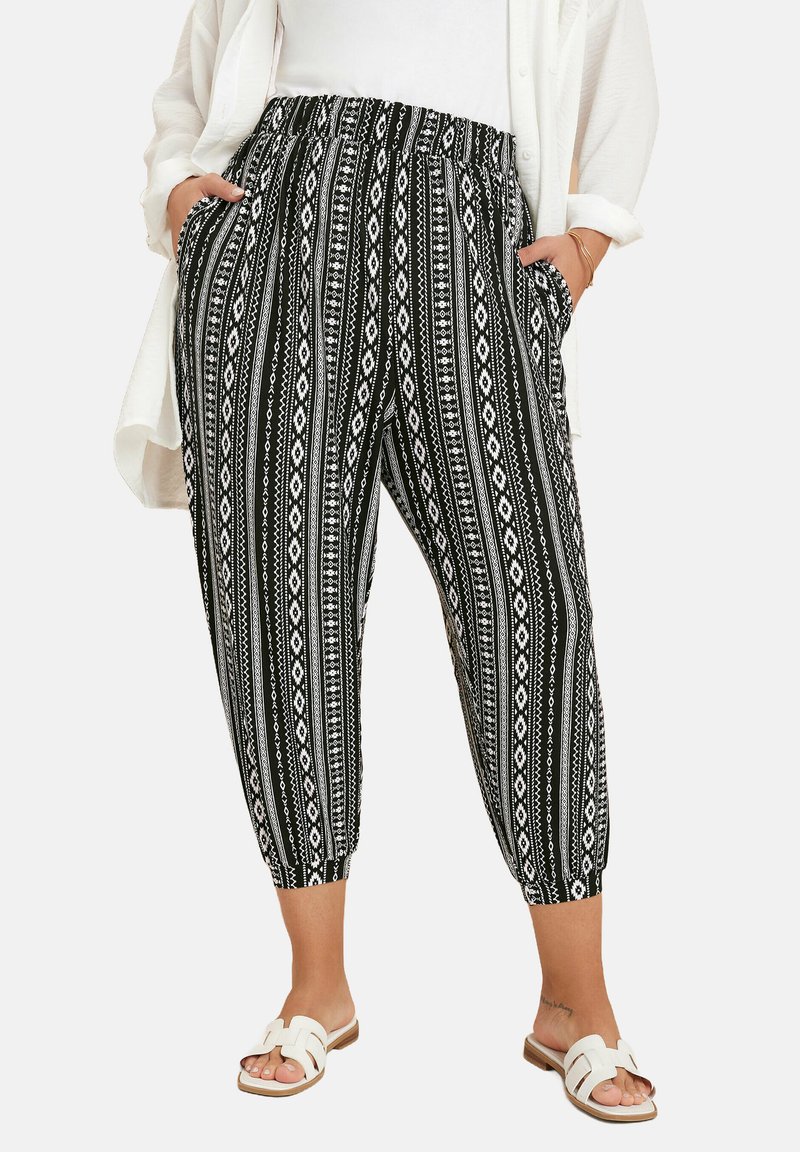 Pantalones capri de patrón en blanco y negro con cintura elástica, bolsillos laterales y un ajuste entallado. Tejido suave con un diseño geométrico.