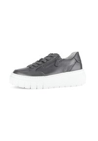 Zwarte leren sneaker met dikke witte platformzool, vetersluiting aan de voorkant en een ritsdetail aan de zijkant op een effen witte achtergrond.