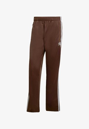 Brown athletic pants made of smooth fabric, featuring white side stripes and an elastic waistband. Includes pockets on both sides.