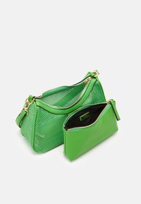 Zelená perforovaná taška přes rameno se zlatým zipem a kováním, doplněná o odpovídající zelenou zipovou kapsičku s černou podšívkou.