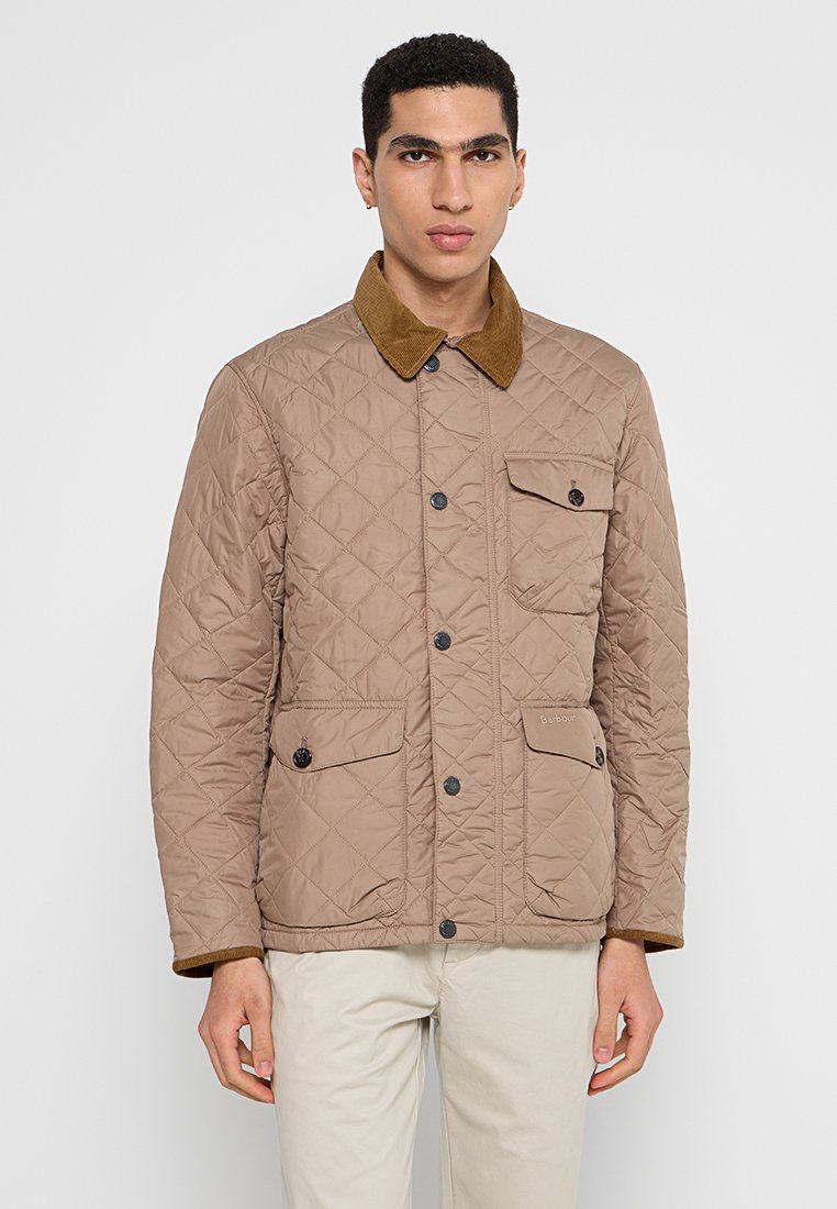 Veste matelassée marron avec col en velours côtelé, comprenant deux poches avant, des boutons-pression et une surface texturée. Design sobre, léger.