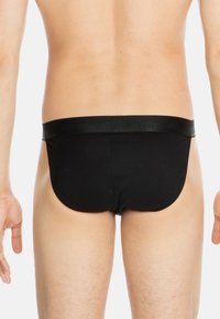 Schwarze Slips mit glatter Textur und elastischem Bund. Schlichtes Design ohne Muster oder Akzente, geeignet für den täglichen Gebrauch.