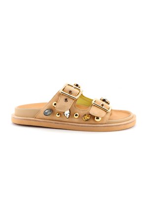 Infradito in suede tan con doppie fibbie regolabili, gemme decorative e accessori in oro. Suola piatta e plantare imbottito.