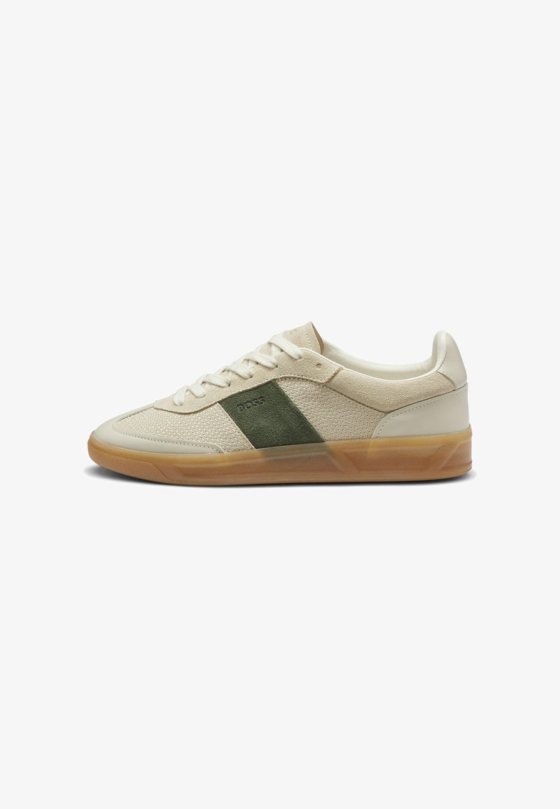 Baskets basses beige avec lacets blancs, panneau latéral en daim vert et semelle en gomme, montrant le côté droit extérieur.