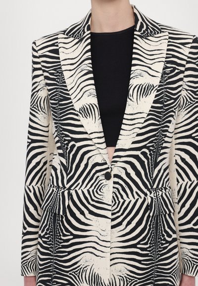 Sort-hvid blazermed zebra-mønster med notched lapels, to frontlommer og en enkelt knaplukning. Letvægtsstof og skræddersyet pasform.
