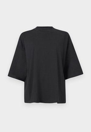 T-shirt noir surdimensionné avec manches courtes, col rond et texture douce en coton. Design simple sans motifs ni embellissements.