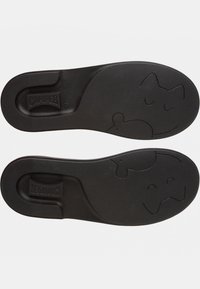 Czarna gumowa podeszwa buta z teksturowaną powierzchnią, logo Camper oraz wytłoczonymi zabawnymi wzorami kota i myszy na spodzie.