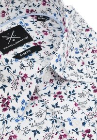 Biała koszula w kwiatowy wzór w odcieniach różu, niebieskiego i ciemnozielonego. Slim fit z wykładanym kołnierzykiem i kontrastowym zapięciem na guziki.