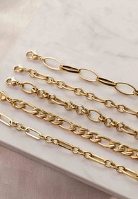 Vier Goldketten mit unterschiedlichen Designs: abwechselnd längliche Ovale und runde Glieder, verschiedene Texturen, mit Verschlüssen an einem Ende.
