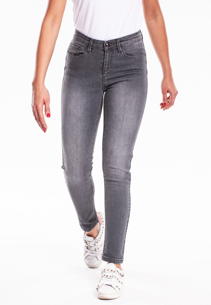 Jean skinny gris en denim avec une texture lisse. Comprend cinq poches, une fermeture à bouton à l'avant et un léger délavage.