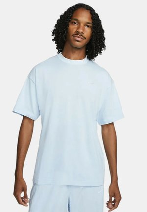 Helles blaues Nike-T-Shirt, kurze Ärmel, runder Ausschnitt, aus weichem Stoff gefertigt. Verfügt über ein kleines Logo auf der Brust. Leicht oversize Schnitt.