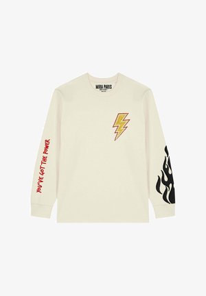 Crèmekleurig shirt met lange mouwen, met een geel-rode bliksempatch op de borst en zwarte vlammengraphics op de linkermouw.
