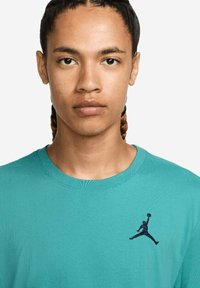 T-shirt turquoise a girocollo realizzato in tessuto testurizzato con il logo Jumpman nero ricamato sul lato sinistro del petto.