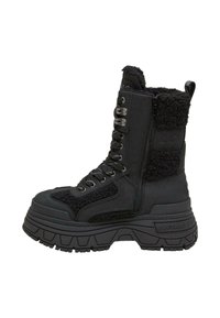Zwarte enkellaars met een combinatie van gladde en gestructureerde stof, een ritsluiting, een chunky zool en metalen oogjes voor de veters.