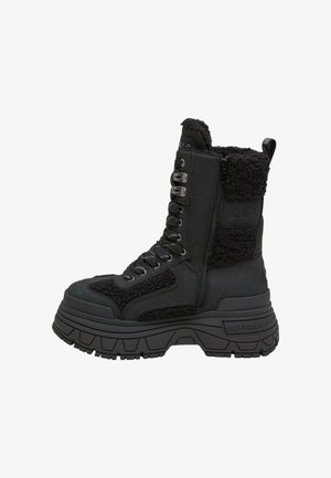 Botine negre până la gleznă, cu un amestec de țesătură netedă și texturată, închidere cu fermoar, talpă groasă și ochiuri metalice pentru șireturi.