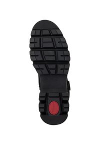 Musta kumikenkien pohja, jossa on uramalli, huomattava kanta, punainen korostus ja kokomerkintä. Tasainen pinta, jossa on kestävä pito.