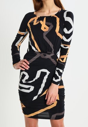 Black long-sleeve dress with geometric patterns in white, beige, and orange. Features a ruched design and round neckline. Soft, stretchy fabric.