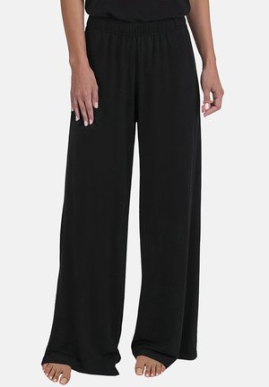 Schwarze weit geschnittene Hosen aus weichem Stoff mit elastischem Bund und lockerer Passform, die eine glatte Textur und entspannte Form aufweisen.
