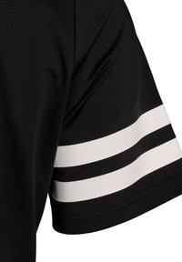 Schwarzes Stoffhemd mit kurzen Ärmeln, das über drei weiße horizontale Streifen an den Ärmeln verfügt. Strukturierte Oberfläche mit einem atmungsaktiven Design.
