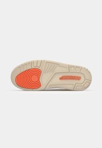 Suela de zapato con una superficie de goma texturizada de color marrón claro, que presenta un destacado acento circular rojo y la marca Jordan. Patrón de banda de rodadura claro para mayor agarre.