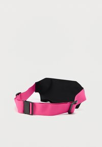 Bande élastique rose avec une section noire à l'arrière et une fermeture à boucle en plastique. Le matériau semble lisse avec une finition mate.