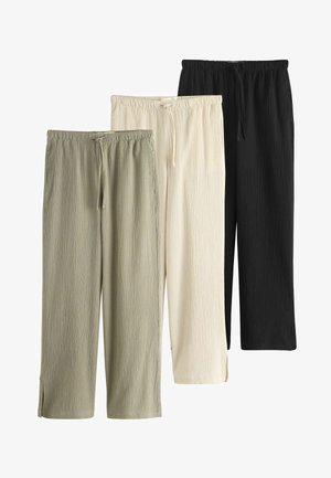 Drei Paare locker sitzender Hosen aus strukturiertem Stoff in Olivgrün, Off-White und Schwarz mit elastischen Bündchen und Kordelzügen.
