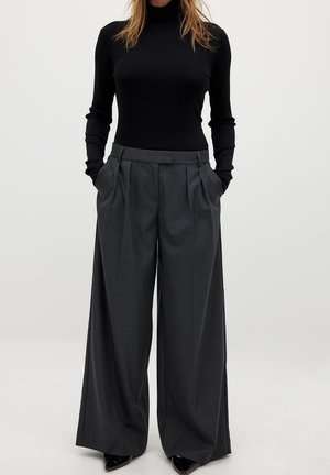 High-waisted, wide-leg trousers in dark gray fabric with a subtle texture, featuring deep pockets and a structured waistband.