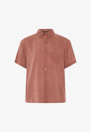 Chemise à manches courtes couleur rouille avec col pointu et poche poitrine, en tissu doux et texturé.