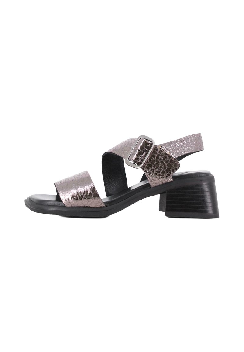 Sandalia de tacón con suela negra, correas metálicas en bronce con un acabado texturizado y un tacón cuadrado y grueso. Acento de hebilla ajustable.