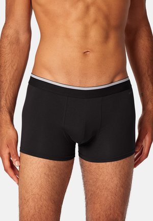 Schwarze Boxer-Brief mit einem weichen elastischen Bund, der über einen grauen Streifen verfügt. Glatte Textur, enganliegendes Design und minimale Nähdetails.
