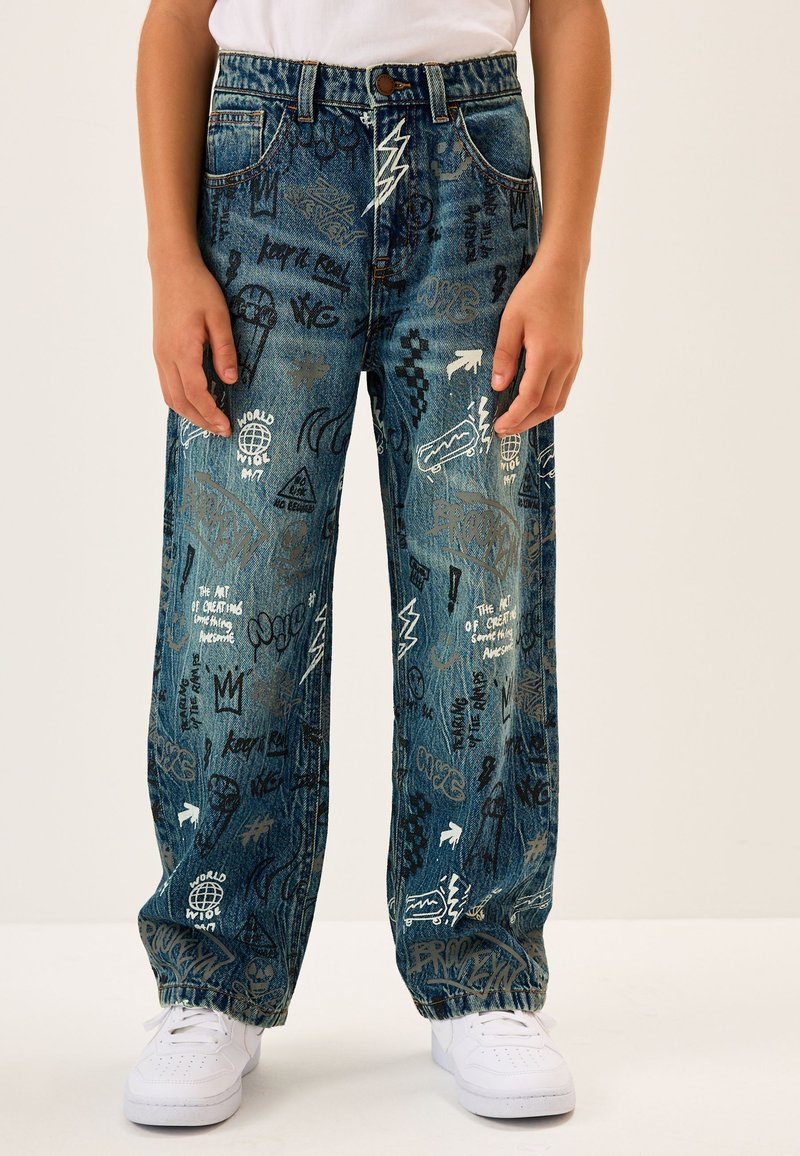 Jeans di denim azzurro chiaro con vestibilità ampia, decorati con varie stampe grafiche bianche e nere e design standard a cinque tasche.
