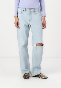 Light blue, high-waisted, wide-leg jeans with a distressed knee. Worn with black and brown leopard print flats.