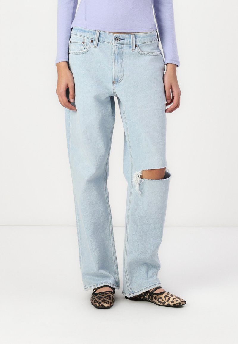 Light blue, high-waisted, wide-leg jeans with a distressed knee. Worn with black and brown leopard print flats.