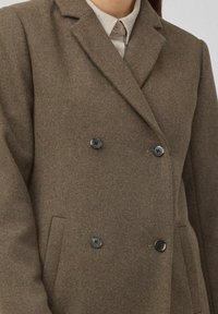 Bruine wolmix dubbelgebutton coat met notch-lapels, twee zwarte knopen en zijzakken voor extra functionaliteit.