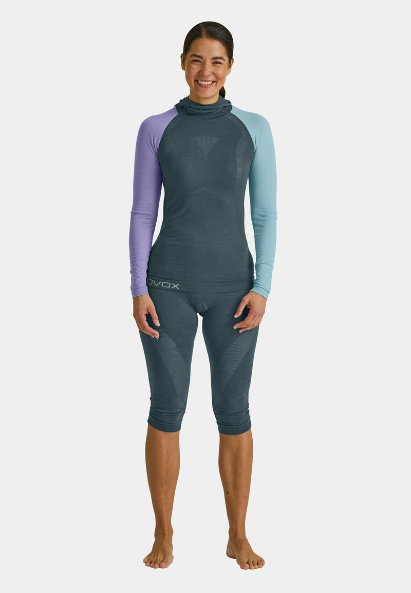 Long-sleeve activewear top in dark gray with lavender and light blue sleeves, paired with dark gray capri bottoms featuring textured accents.
