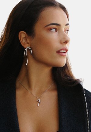 Silver earrings with a curving, elongated design and a matching pendant necklace. The textures are sleek, with a polished shine.