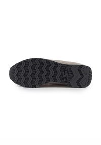 Semelle de chaussure en caoutchouc avec un motif de bande de roulement en zigzag, surface texturée et logo de la marque. La couleur est noire avec des accents gris clair sur le dessus.