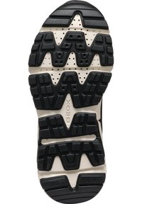 Suela de goma negra con un patrón texturizado y perforaciones, que presenta una entresuela de color crema claro con un logotipo prominente.