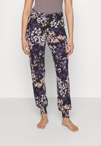 Zwarte bloemenbroek met paarse, witte en oranje bloemmotieven. Elastische tailleband en gerimpelde boorden bij de enkels. Lichte stof.