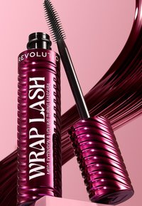 Rosa maskaraboks med rillet design, med svart applikatorstang. Teksten lyder "WRAP LASH MEGA EXTENSION & VOLUME TUBING MASCARA."