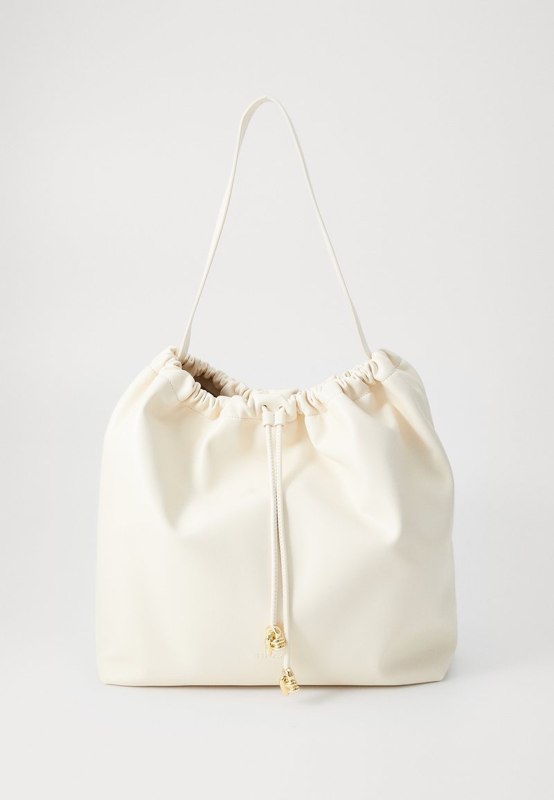Sac à cordon en faux cuir blanc et doux avec un dessus froncé, une bandoulière réglable et des accents en métal doré. Texture lisse avec un design minimaliste.