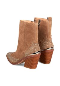 Botas de tobillo de ante color arena con un diseño con ondas, adornadas con rhinestones en la puntera y el talón, con un tacón de madera apilada.