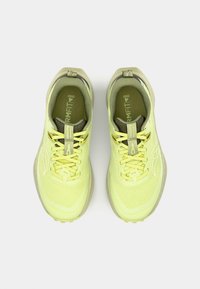 Baskets de course jaunes avec une tige en mesh, des accents ton sur ton et un col rembourré. La semelle extérieure présente des détails de traction pour la stabilité.