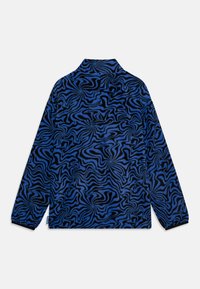 Chemise en polaire bleue avec un motif noir tourbillonnant, manches longues et col. Texture douce avec une coupe décontractée.