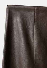 Tejido de cuero sintético marrón oscuro con una superficie texturizada y detalles de costura visibles, que presenta un acabado suave y ligeramente brillante.