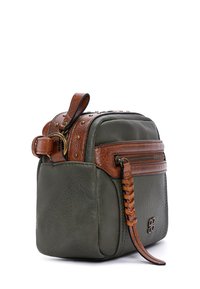 Sac en cuir vert olive avec bandoulière tressée marron, clous en laiton et compartiment zippé. Forme carrée avec des détails de surface texturée.