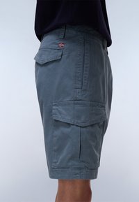 Gray cargo shorts made from a smooth fabric. Features multiple pockets, a back pocket with a small flag detail, and a knee-length cut.