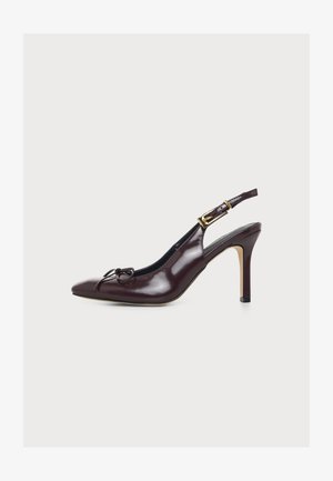 Ciemnoczerwone bordo buty na obcasie typu slingback z ostrym noskiem, małą kokardką i regulowanym złotym paskiem z klamrą na białym tle.
