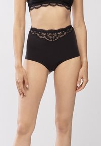 Högmidjade svarta trosor tillverkade av mjukt material med intrikata svarta spetsdetaljer längs midjebandet, vilket ger kontrast och textur.