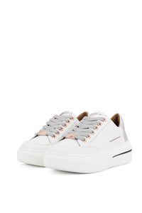 Sneakers bianchi in pelle con lacci grigi, occhielli in oro rosa e un accento sul tallone beige. Presentano una suola spessa bianca e un branding minimale.
